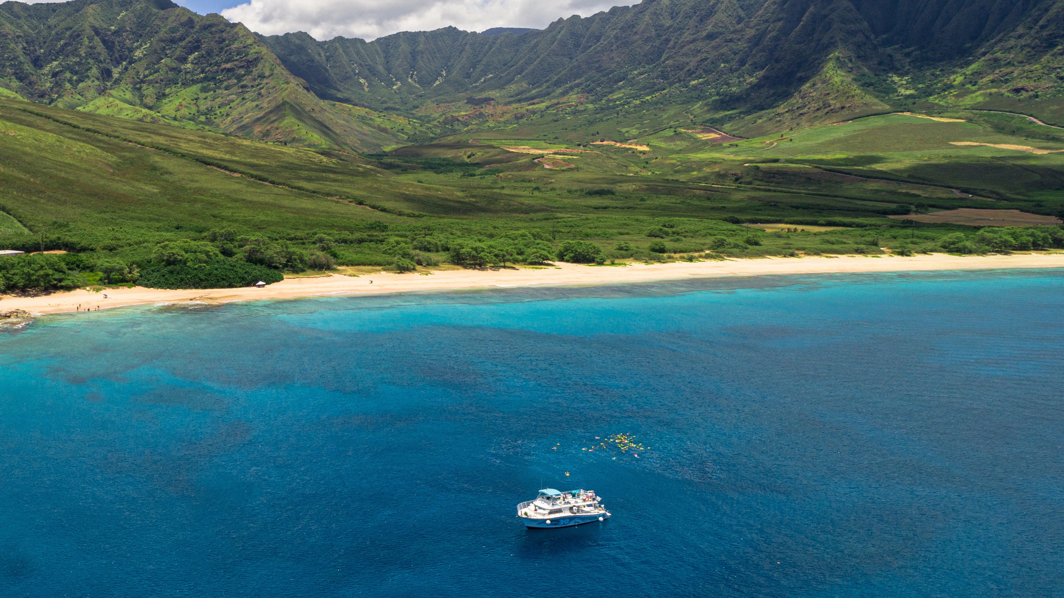 Waiʻanae coast aerial view with And You Creations boat and snorkelers in turquoise water